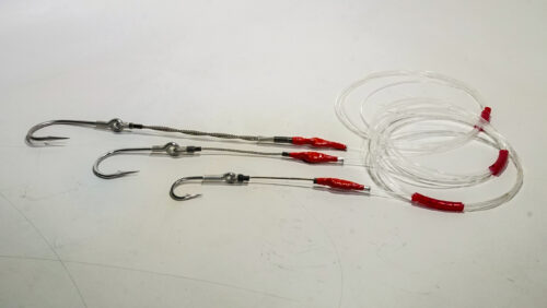A white table with some fishing hooks and wires